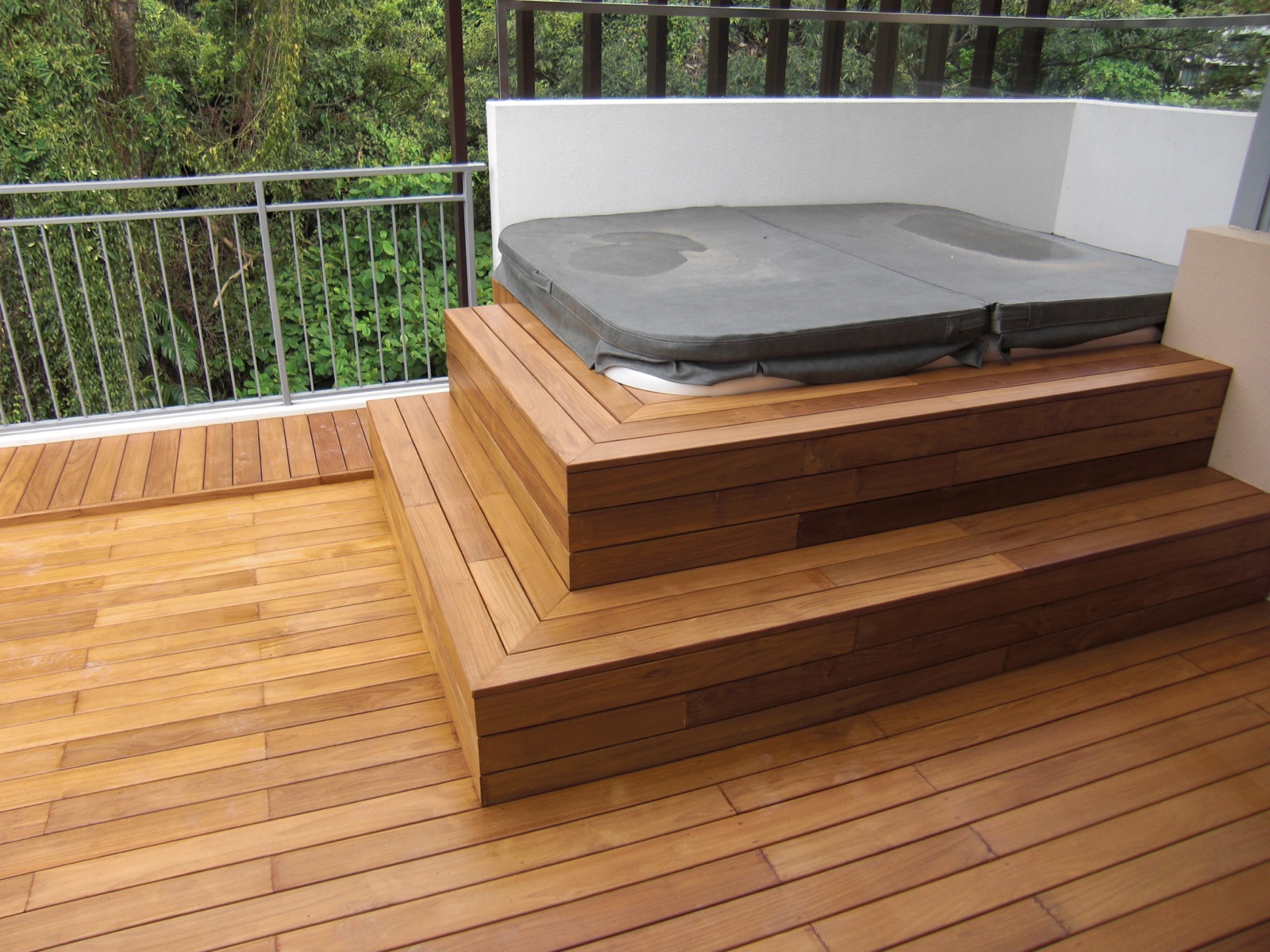 Teak surround built around a hot tub in a wet exterior setting