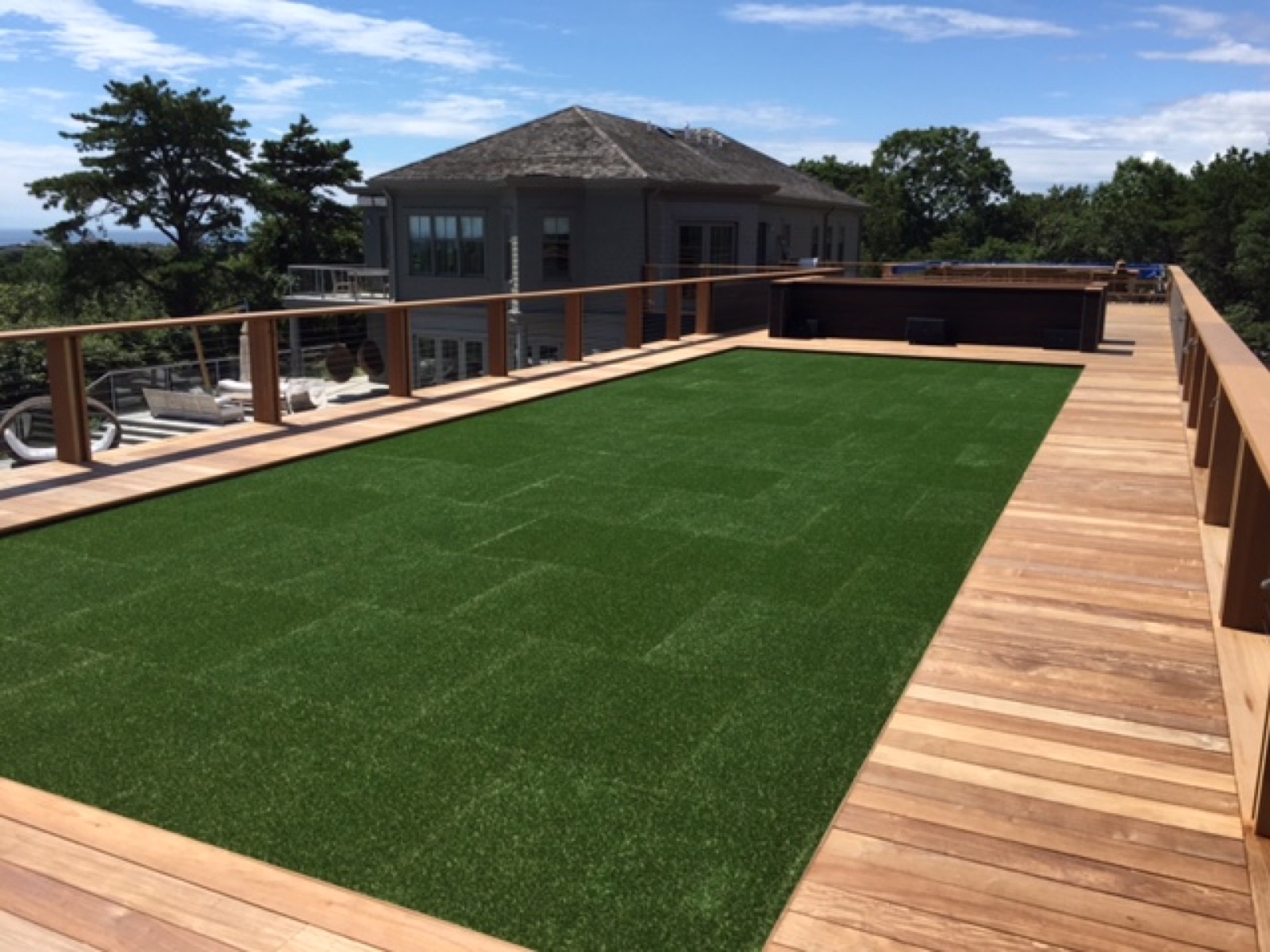 Tropical hardwood deck bordering a lawn