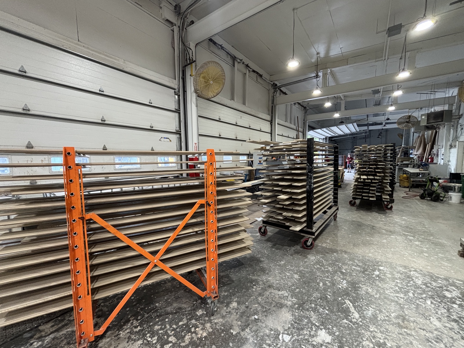 Racks of primed millwork staged on the shop floor