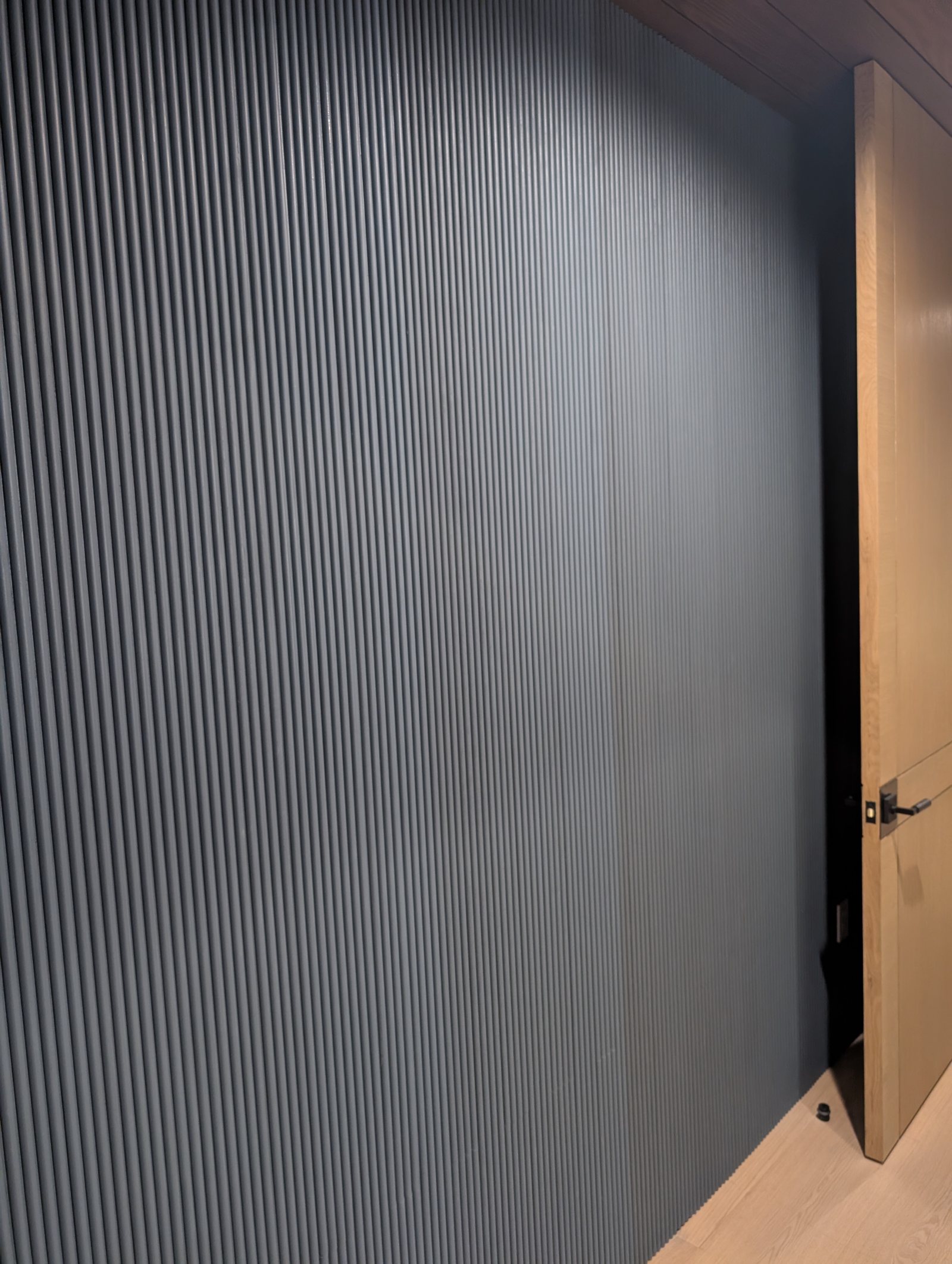 Reeded modified panel face running past a door opening