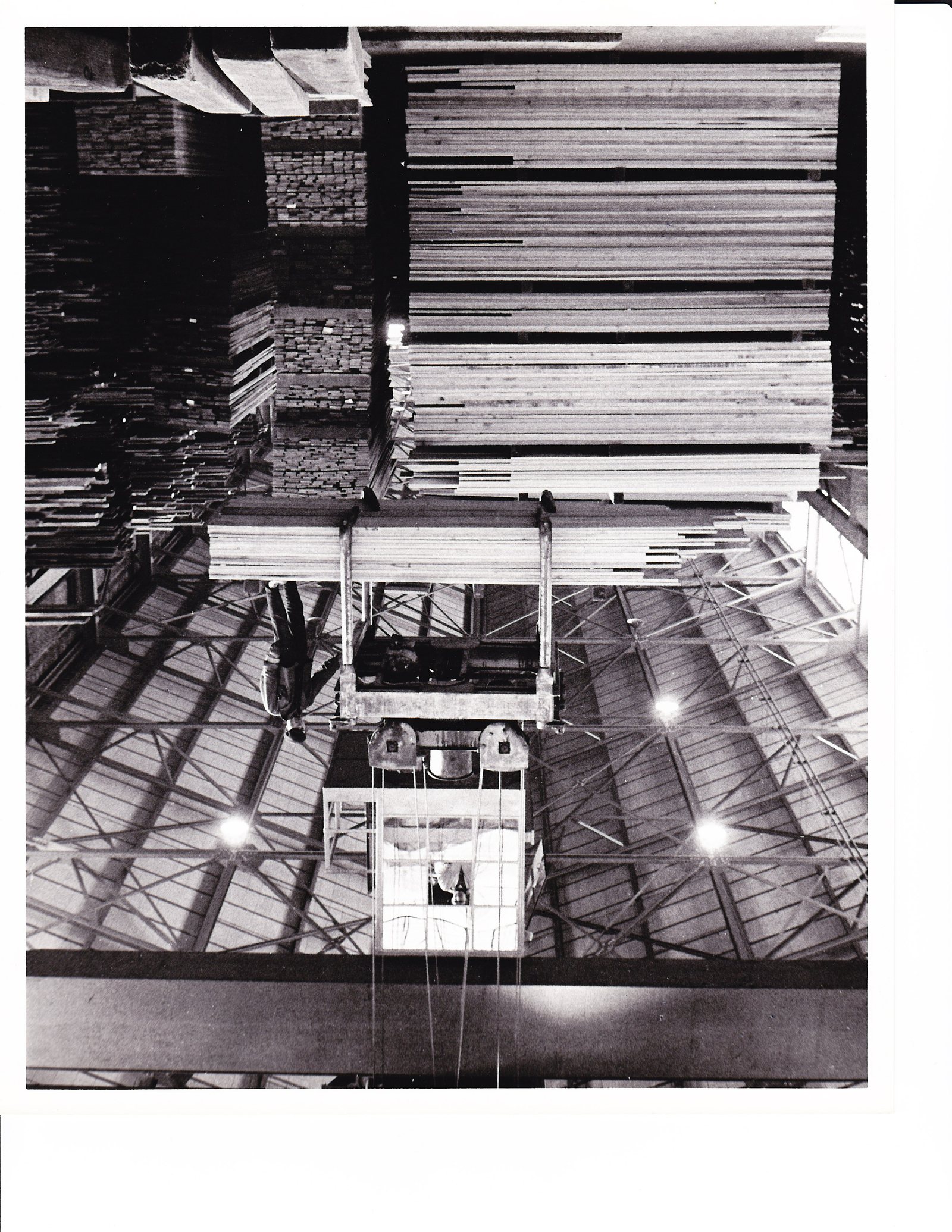 Lumber being moved by crane in the company yard