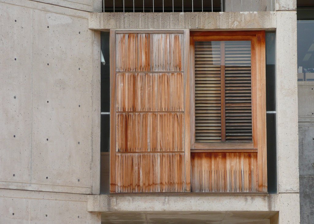 The same teak window wall before restoration, showing weathered surfaces